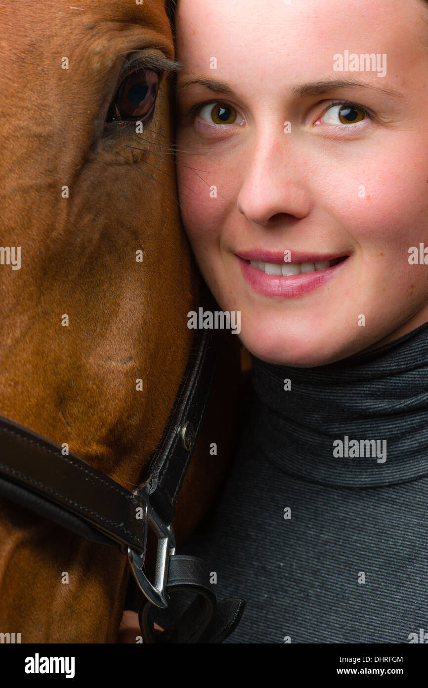 Donna e cavallo insieme, donna guarda verso la telecamera, formato verticale Foto Stock