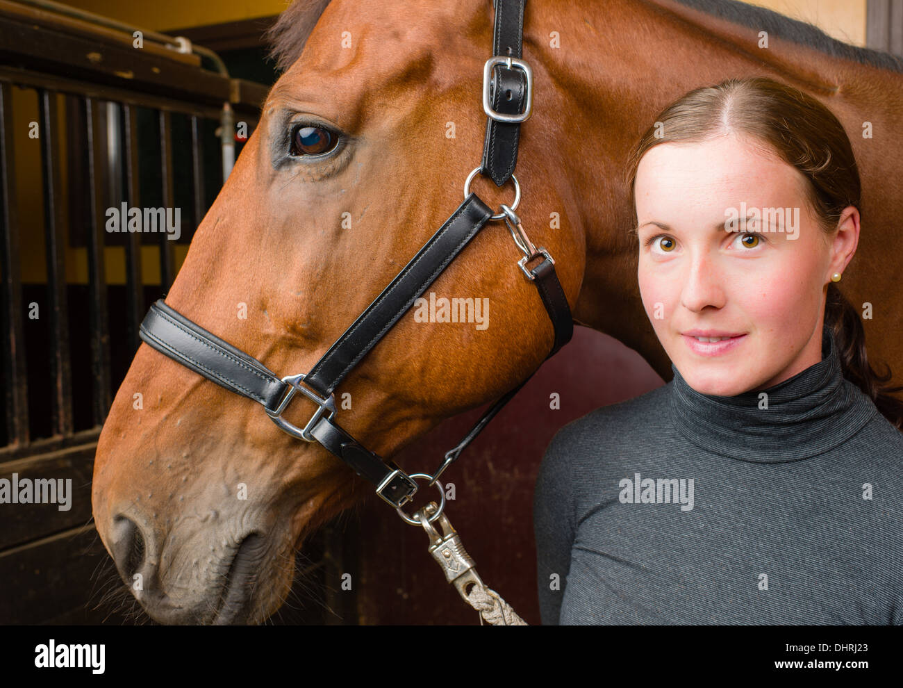 Donna e cavallo, donna guarda verso la telecamera Foto Stock
