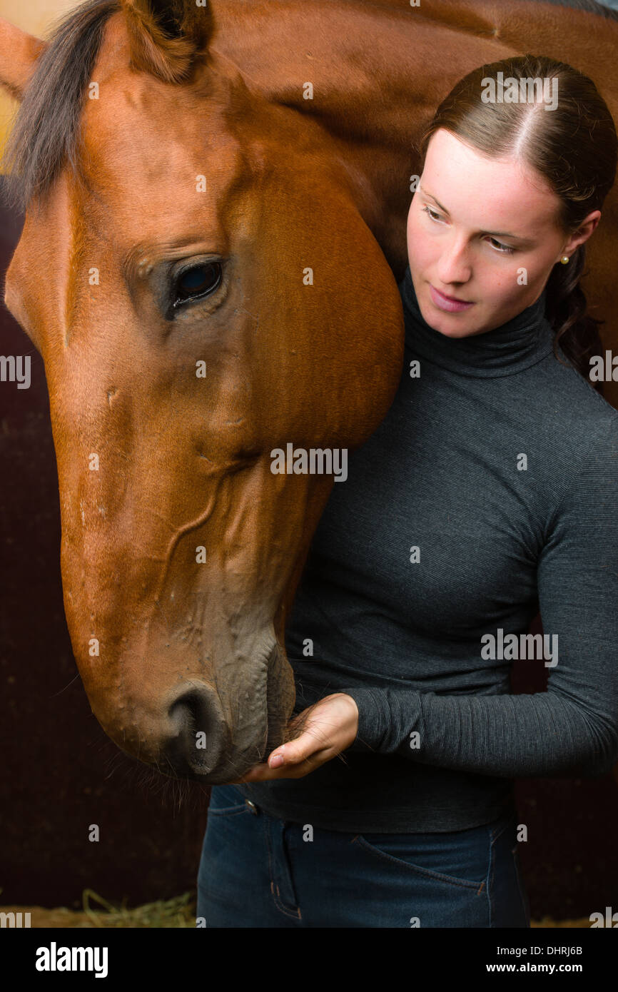 La donna danno un bocconcino a cavallo, formato verticale Foto Stock