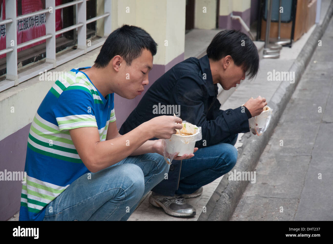 Uomini di mangiare cibo di strada per colazione, Shanghai, Cina Foto Stock