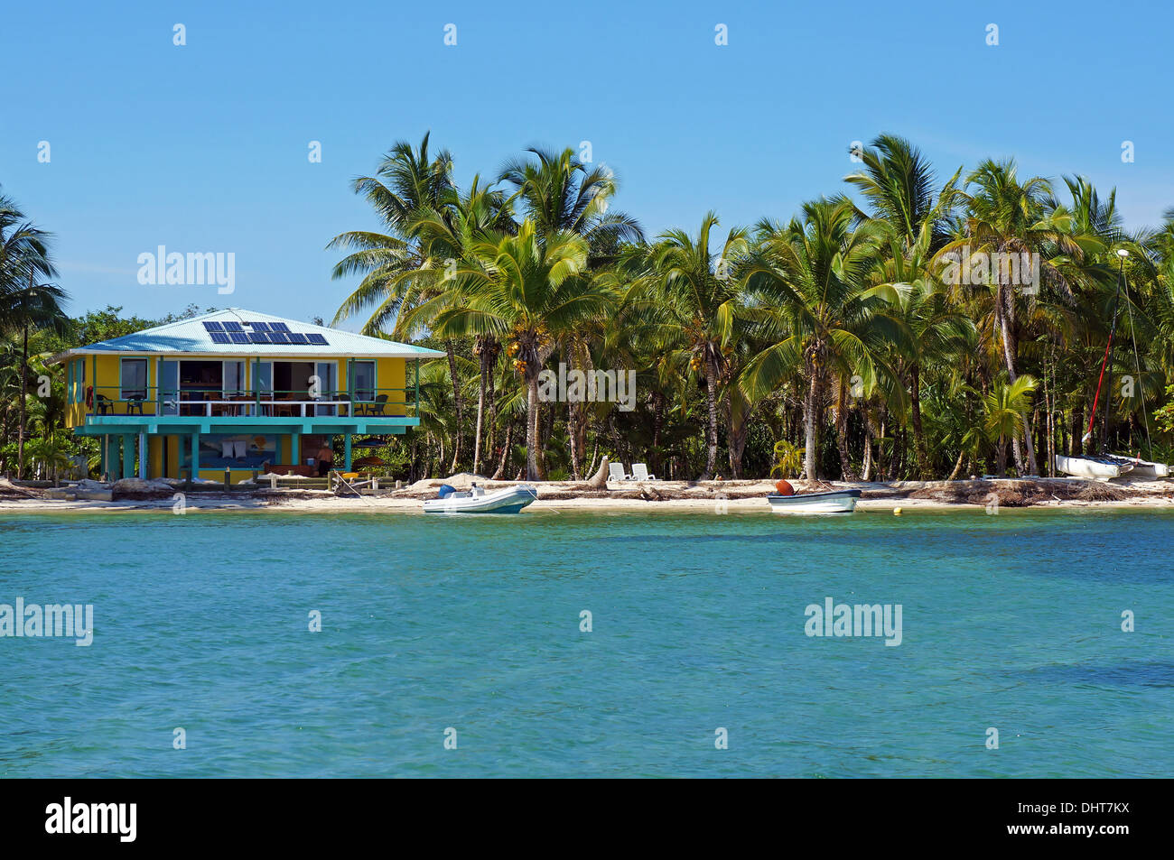 Spiaggia tropicale con powered solar beach house e alberi di noce di cocco, Caraibi, Bocas del Toro, Panama Foto Stock