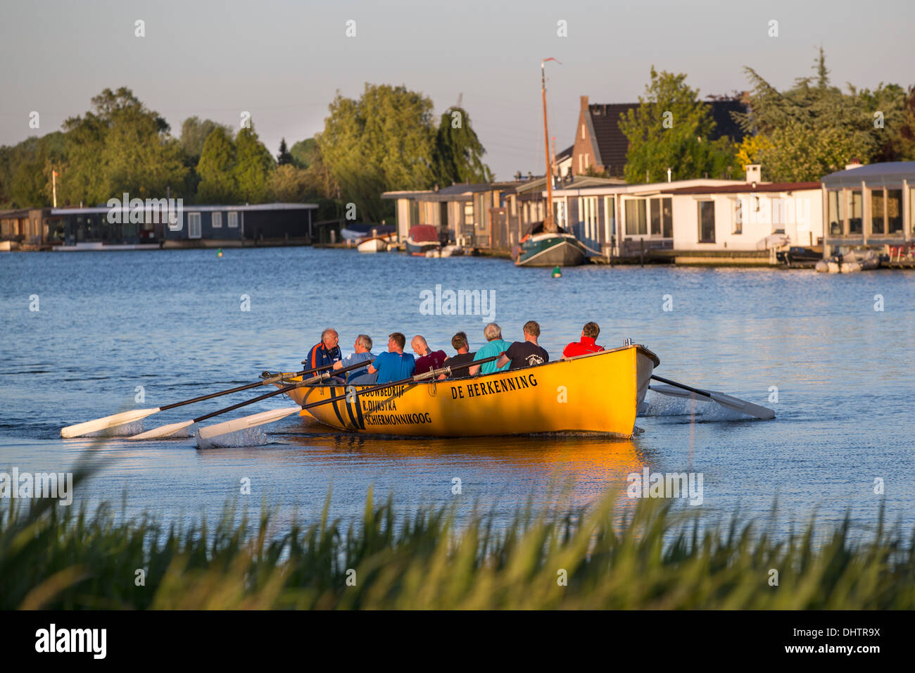 Paesi Bassi, Weesp, persone canottaggio sul fiume Vecht. Case galleggianti Foto Stock