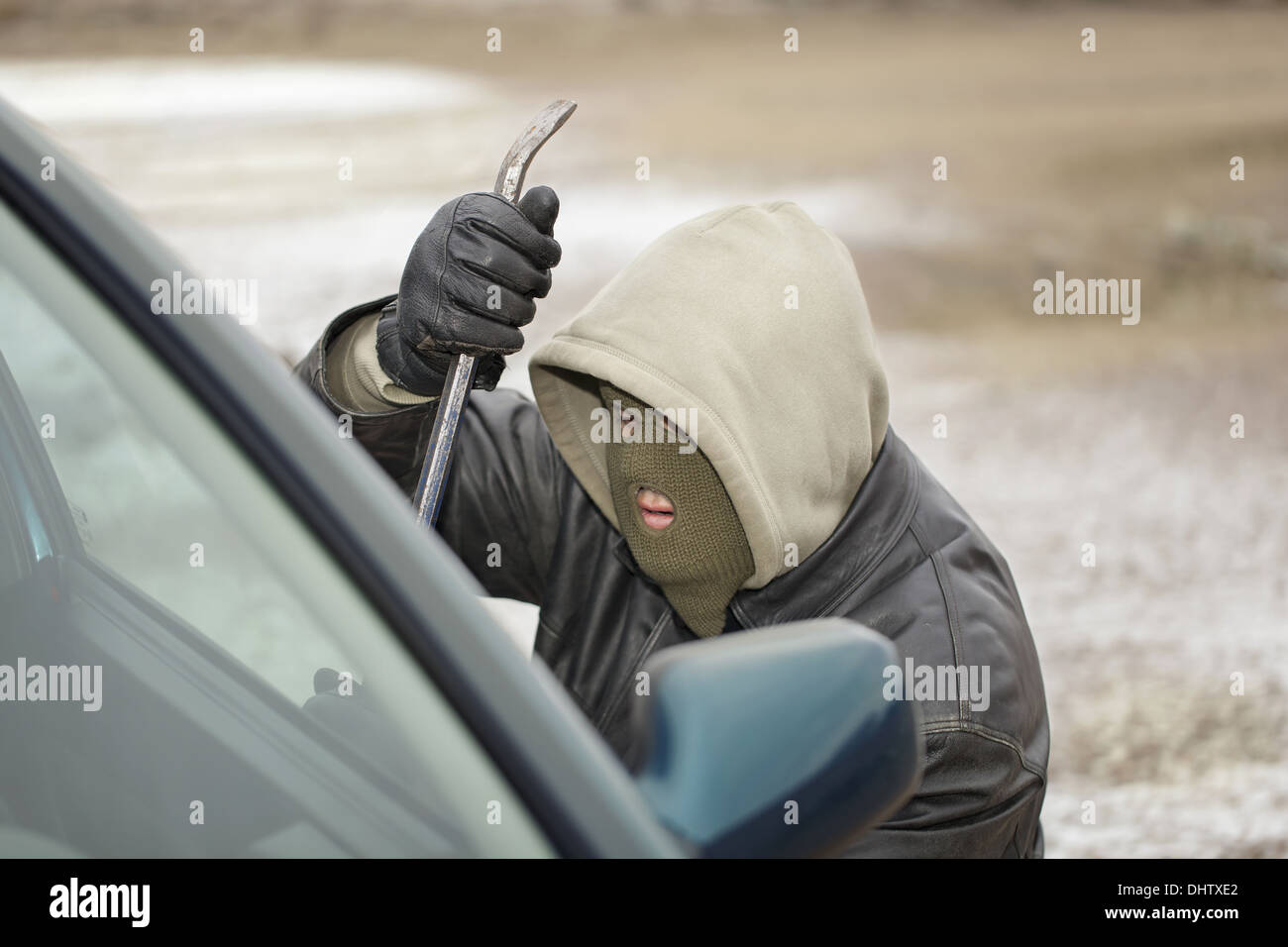 Rapinatore cercando di aprire la portiera della macchina Foto Stock
