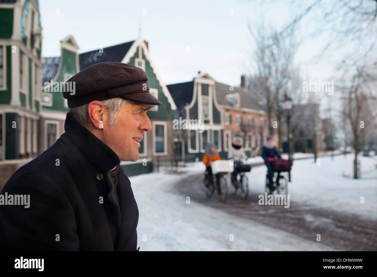 Paesi Bassi, Zaanse Schans vicino a Zaandam, aria aperta di attrazione turistica. L'inverno. Miller e le ragazze su biciclette andando a scuola Foto Stock