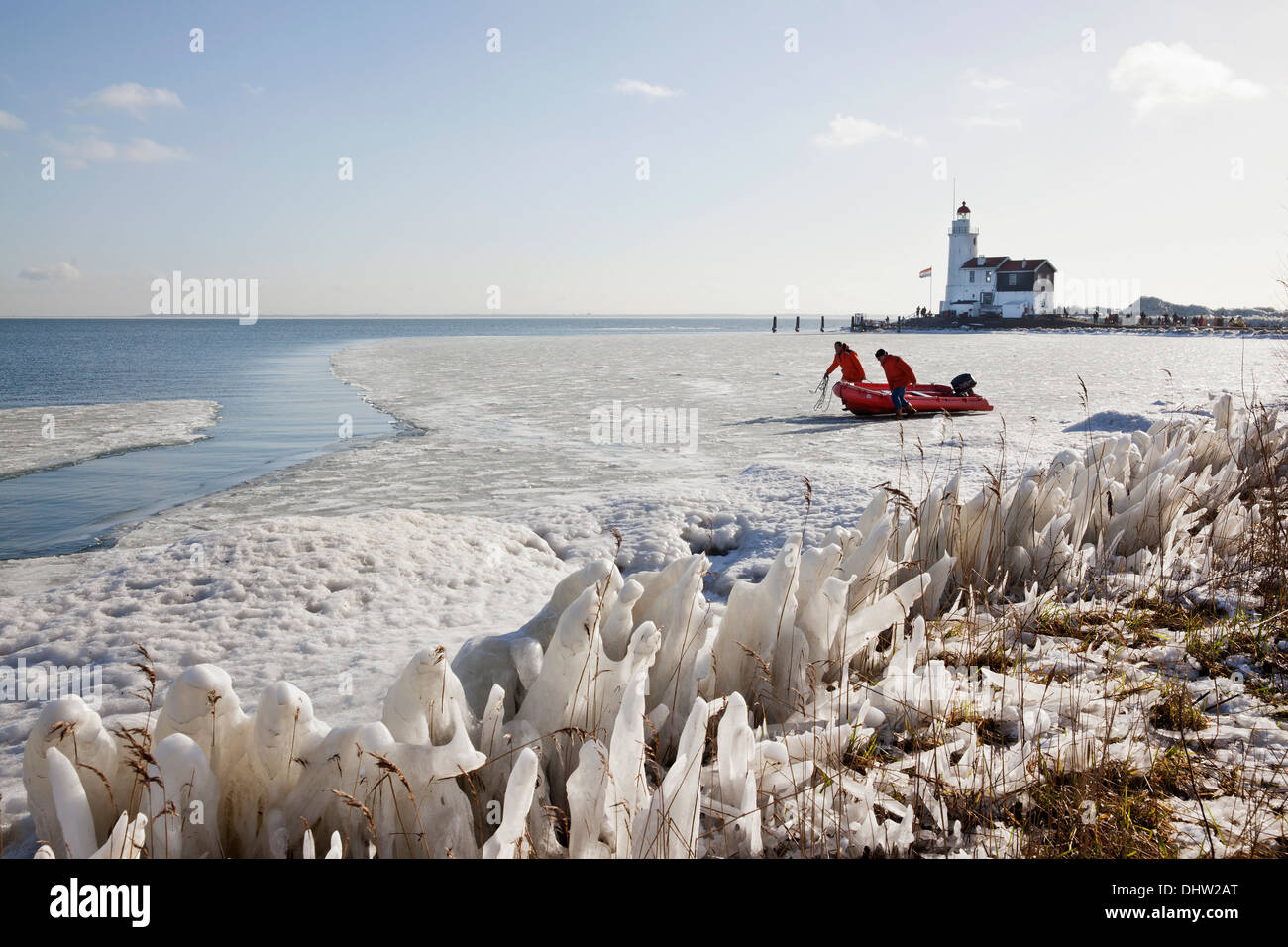 Paesi Bassi, Marken, chiamato lago IJsselmeer. L'inverno. Faro chiamato Het Paard. La preparazione di barca per tour su open water Foto Stock