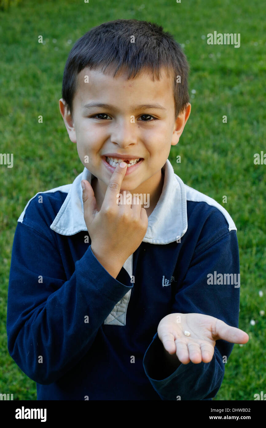 7-anno-vecchio ragazzo che mostra un dente mancante Foto Stock