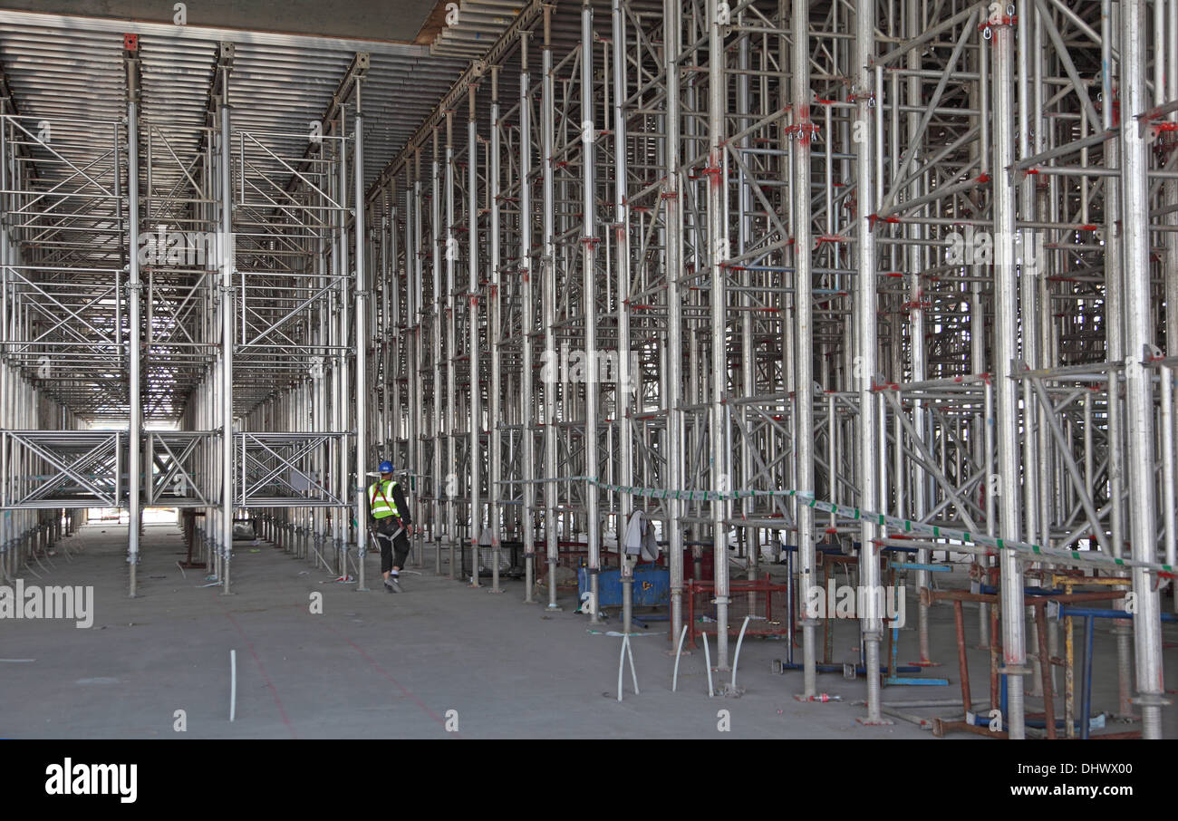 Un costruttore di passeggiate tra 8 metro alto cassero in alluminio di strutture di sostegno per la costruzione di un nuovo supermercato di Londra. Foto Stock
