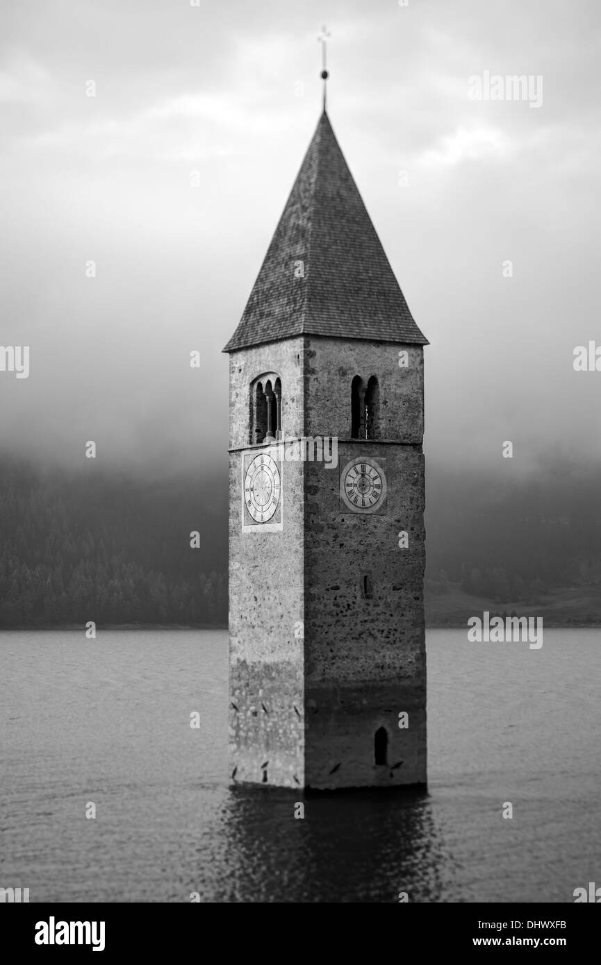 La parte superiore del vecchio campanile di Curon Venosta village - Italia - emerge dall'acqua Foto Stock