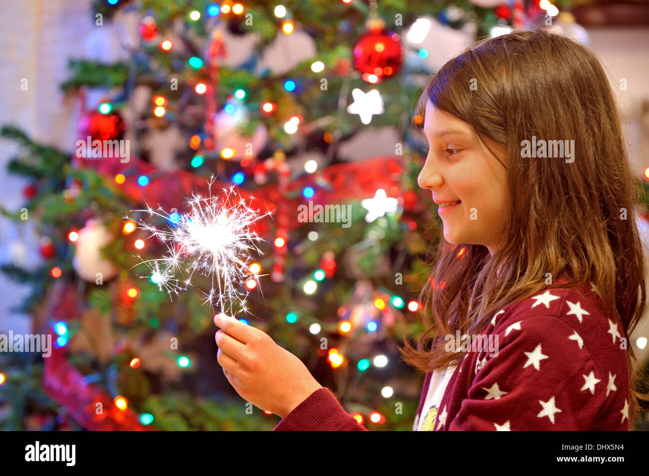 Ragazza giovane celebrando holding sparkles Foto Stock