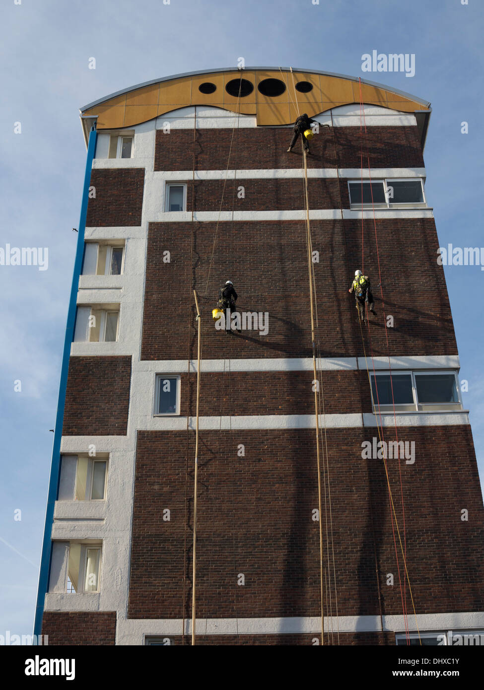 Pulizia dei lavoratori le pareti di un alloggiamento del consiglio estate in Hackney, Londra, Regno Unito Foto Stock
