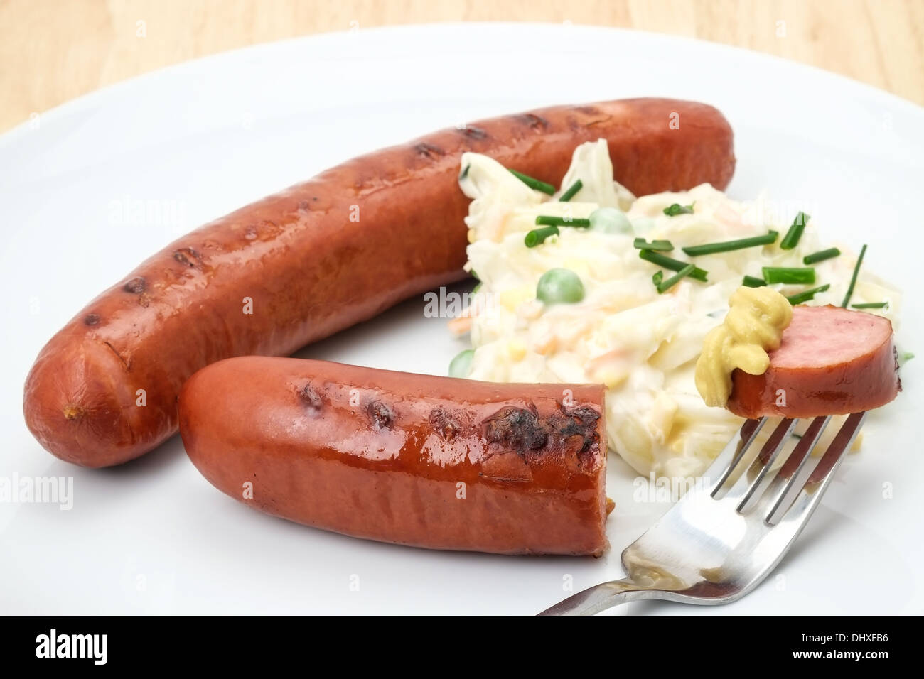 Close-up di un pronto a mangiare tedesco salsicce bratwurst servita con coleslaw e senape. Foto Stock