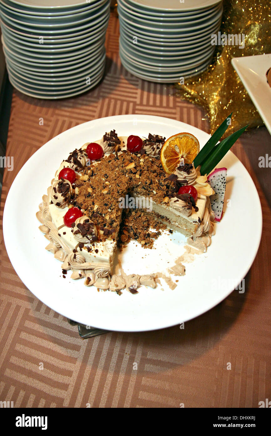 La Foto di cioccolato torta di frutta è tagliato in bianco piatto. Foto Stock