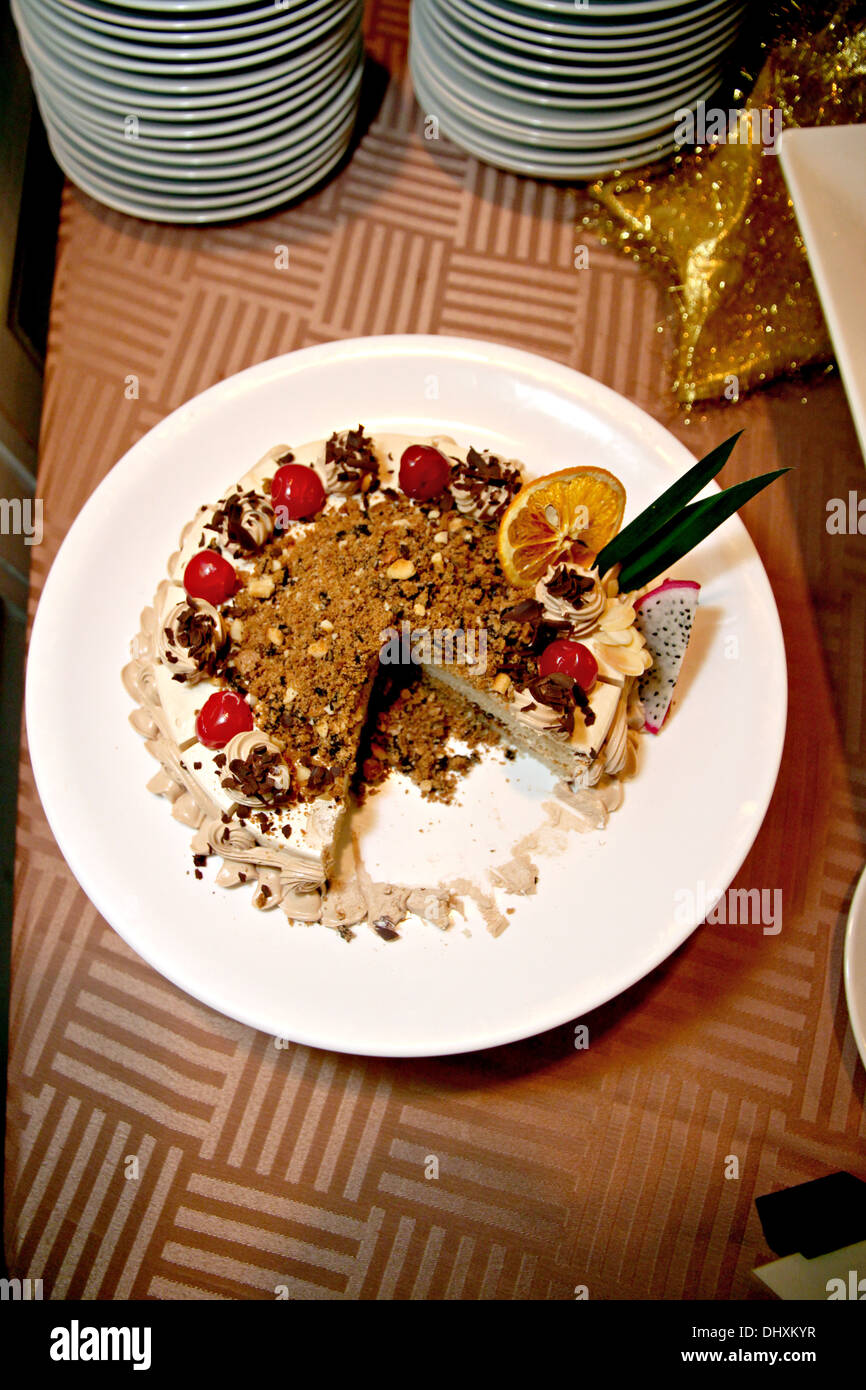 La Foto di cioccolato torta di frutta è tagliato in bianco piatto. Foto Stock