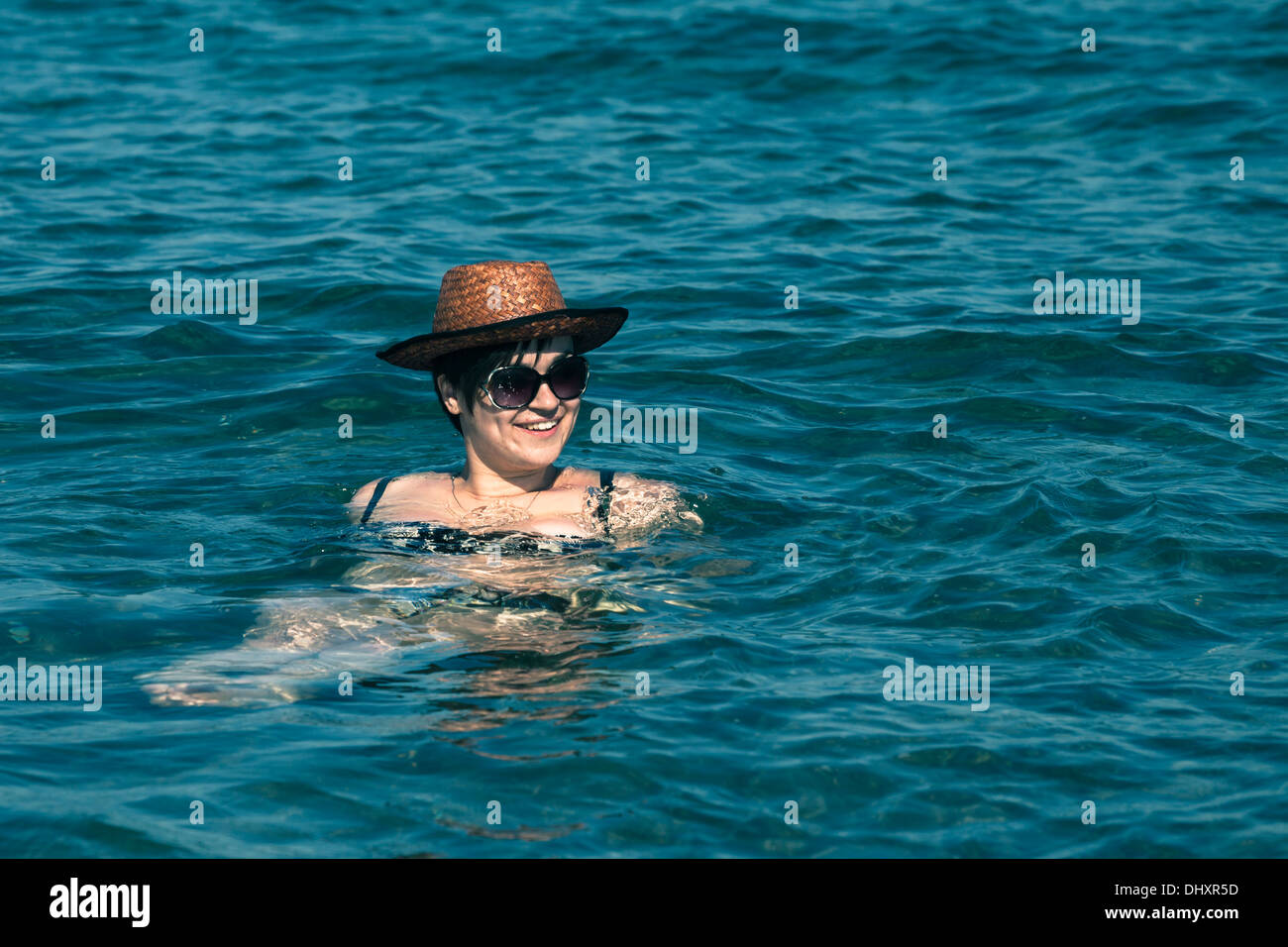 Giovane donna felice in hat nuotare nel mare. Foto Stock