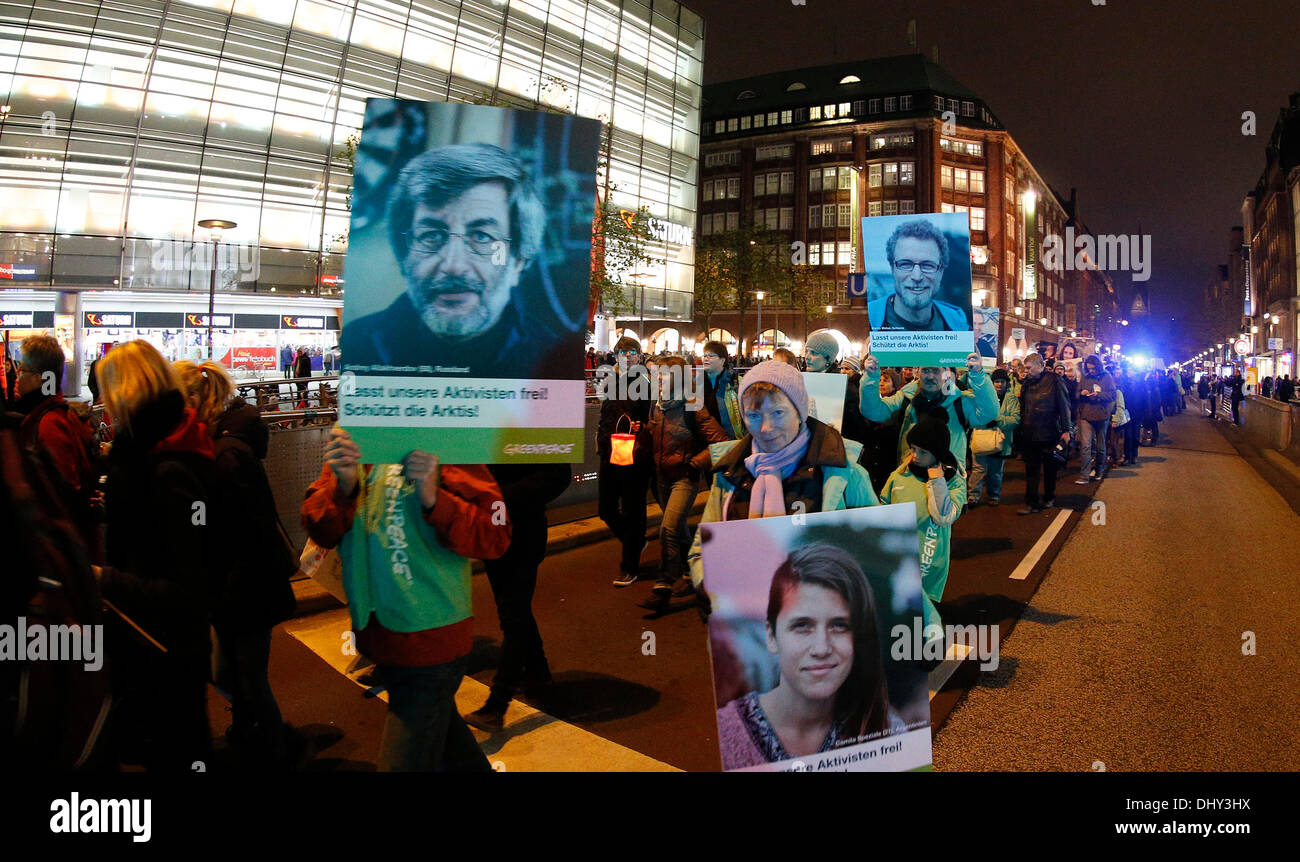 Amburgo, Germania. Xvi Nov, 2013. I dimostranti tenere lanterne e poster con le foto degli attivisti di Greenpeace imprigionato in Russia ad Amburgo, Germania, 16 novembre 2013. Greenpeace dimostra in sei città tedesche con la lanterna marche per il rilascio del loro attivisti dal russo di detenzione. Foto: Axel Heimken/dpa/Alamy Live News Foto Stock