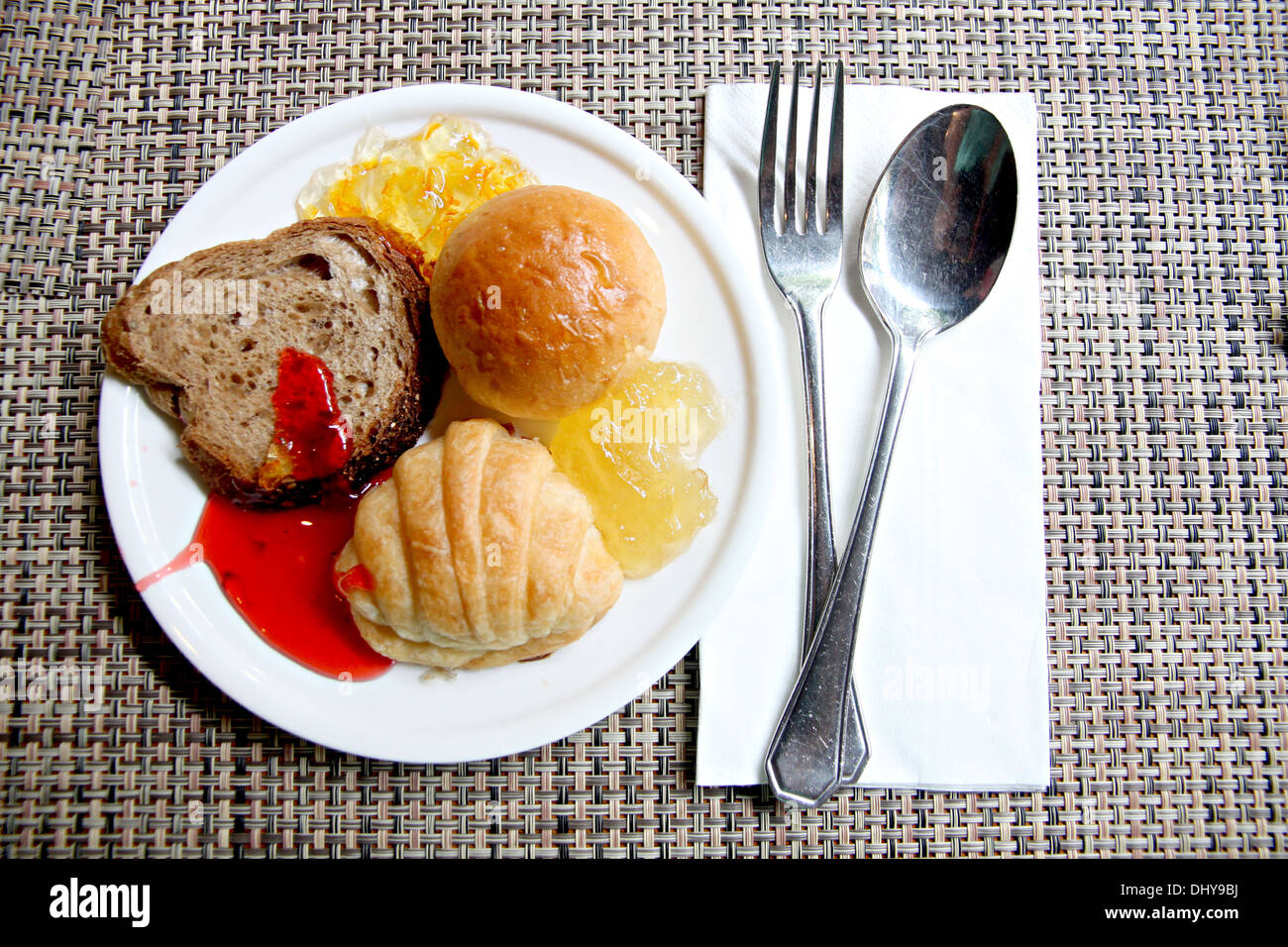 Pane e marmellata in bianco piatto della prima colazione. Foto Stock