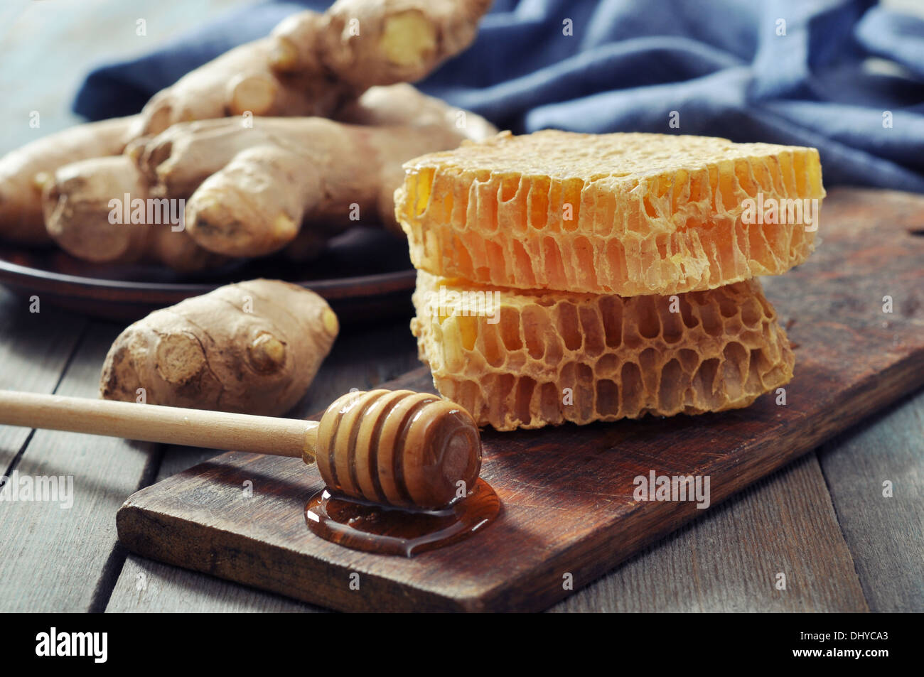 Favo di miele con lo zenzero fresco su vintage sfondo di legno Foto Stock