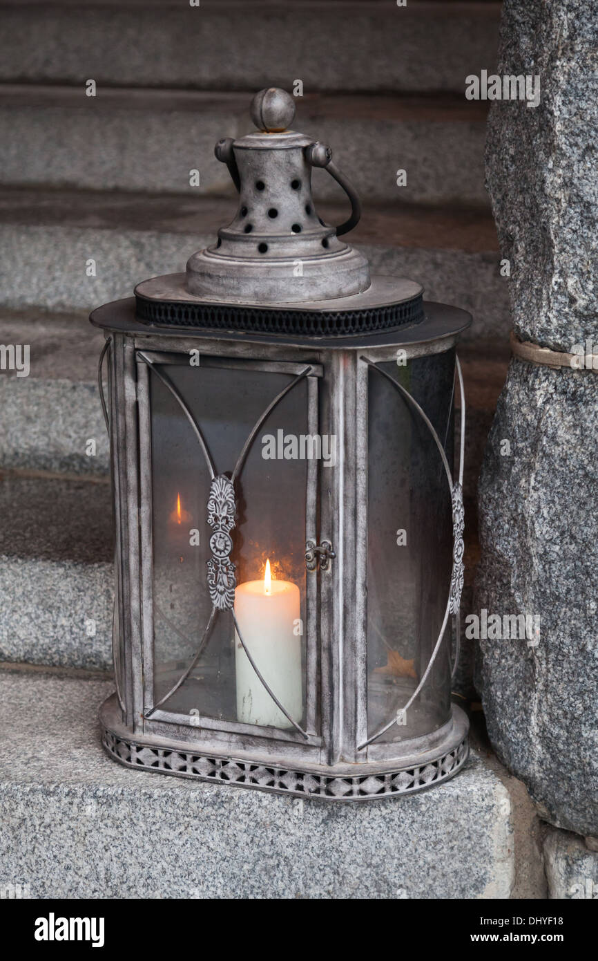 Metallo vecchia lampada da esterni con candela che brucia si erge su scale  in pietra Foto stock - Alamy