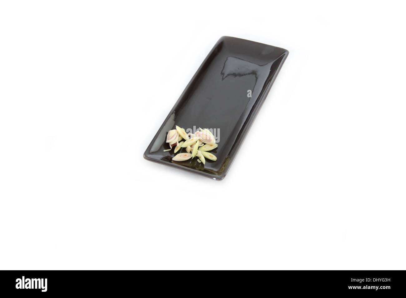 Primo piano freschi di Erba di limone e tagliarlo nel piatto nero su sfondo bianco. Foto Stock