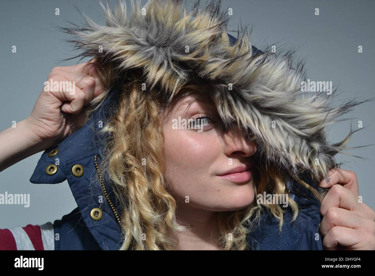 Cofano sollevato, modello si affaccia rivelando un occhio al di sotto di un rivestimento in pelliccia cofano Foto Stock