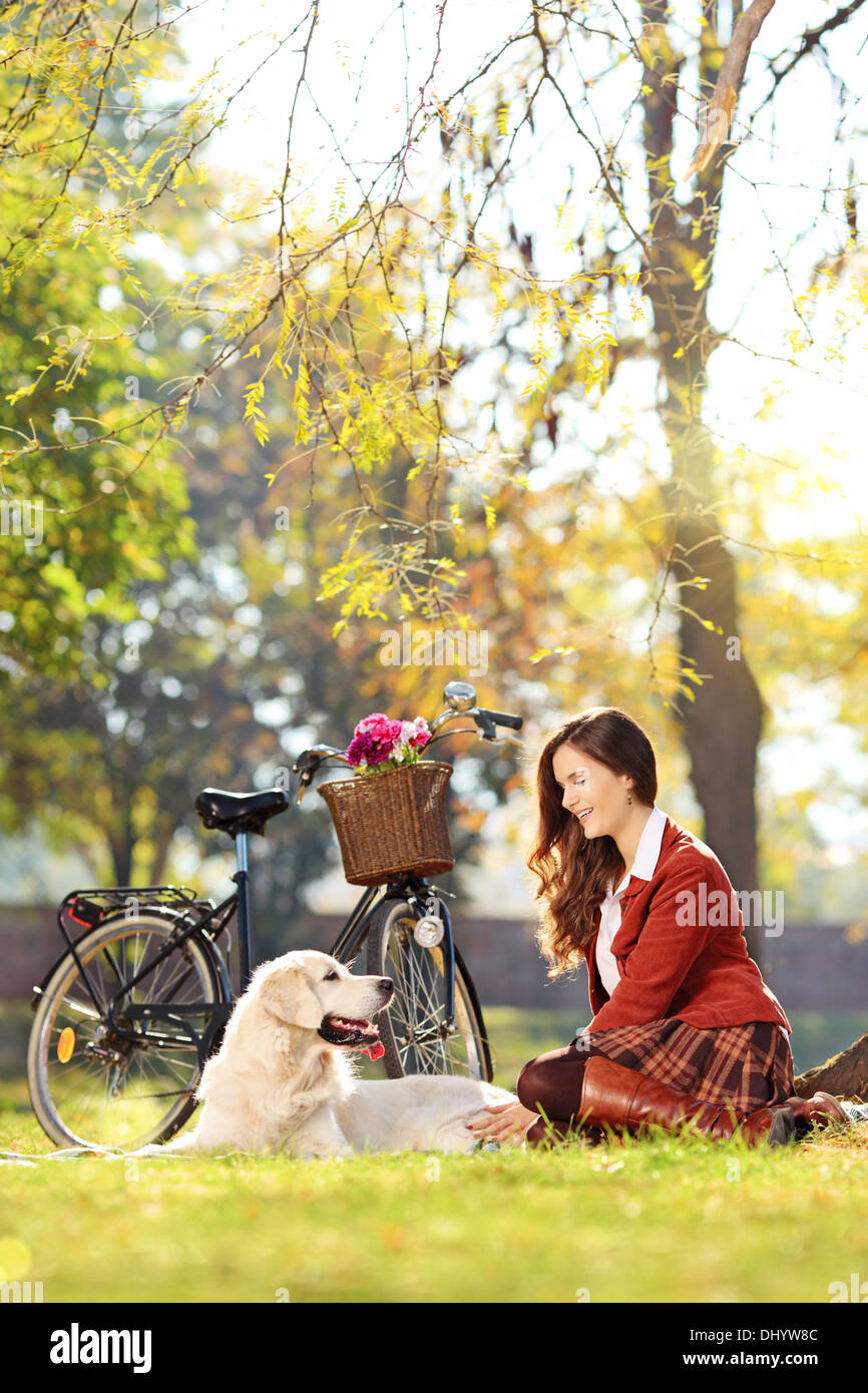 Bella femmina seduto con il suo cane in un parco Foto Stock