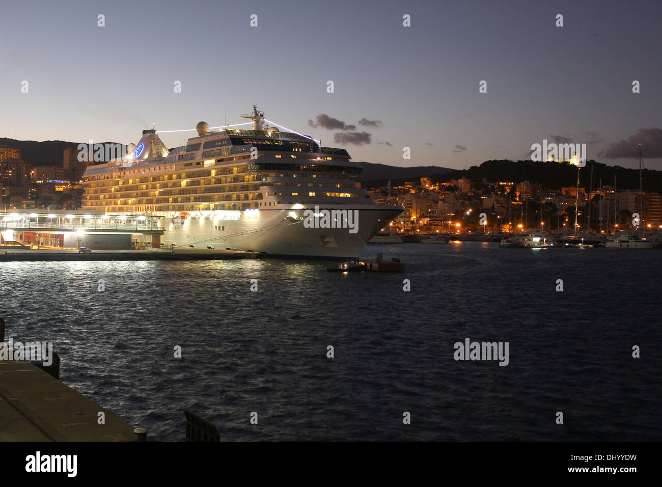 Oceania Cruises nave da crociera "marina" (238 metri) sulla banchina di ormeggio al tramonto - con il famoso castello di Belver, Palma de Mallorca. Foto Stock