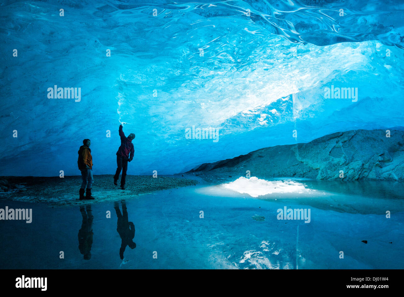 Due persone in piedi all'interno di una caverna di ghiaccio al ghiacciaio Nigardsbreen a Jostedalsbreen, in Europa la più grande calotta di ghiaccio, Foto Stock