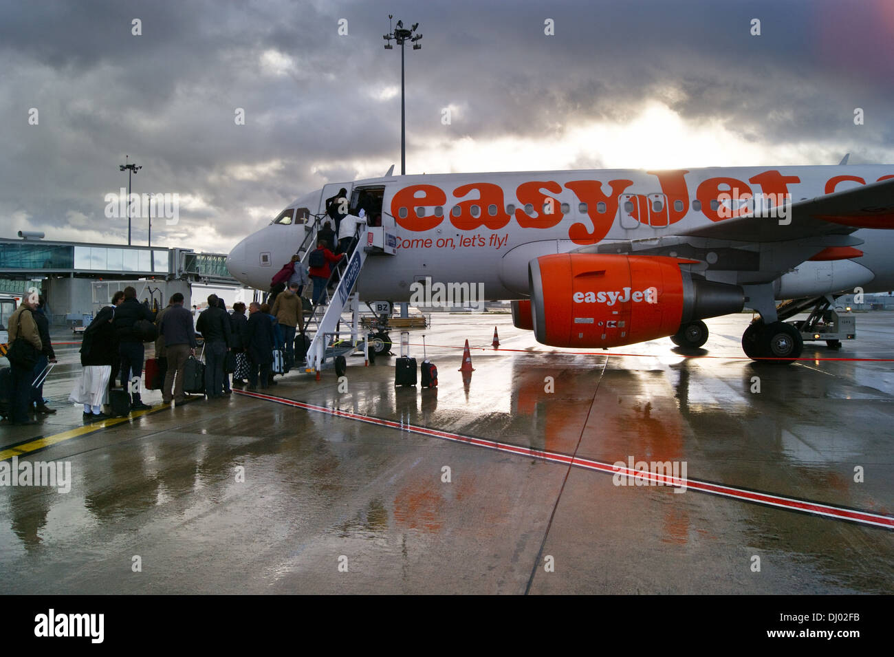 Imbarco passeggeri Easyjet Airbus A320 aereo di linea sotto la pioggia a aeroporto di Tolosa, Haute-Garonne, Midi- Pyréneés, Occitanie, Francia Foto Stock