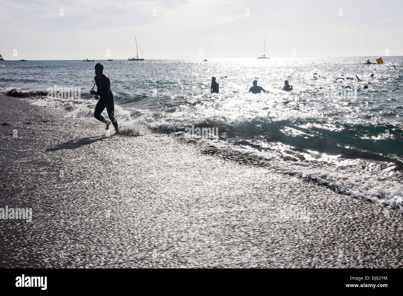 Sagome di nuotatori che emergono dal mare all'oceano triathlon di lava a playa del carmen Foto Stock