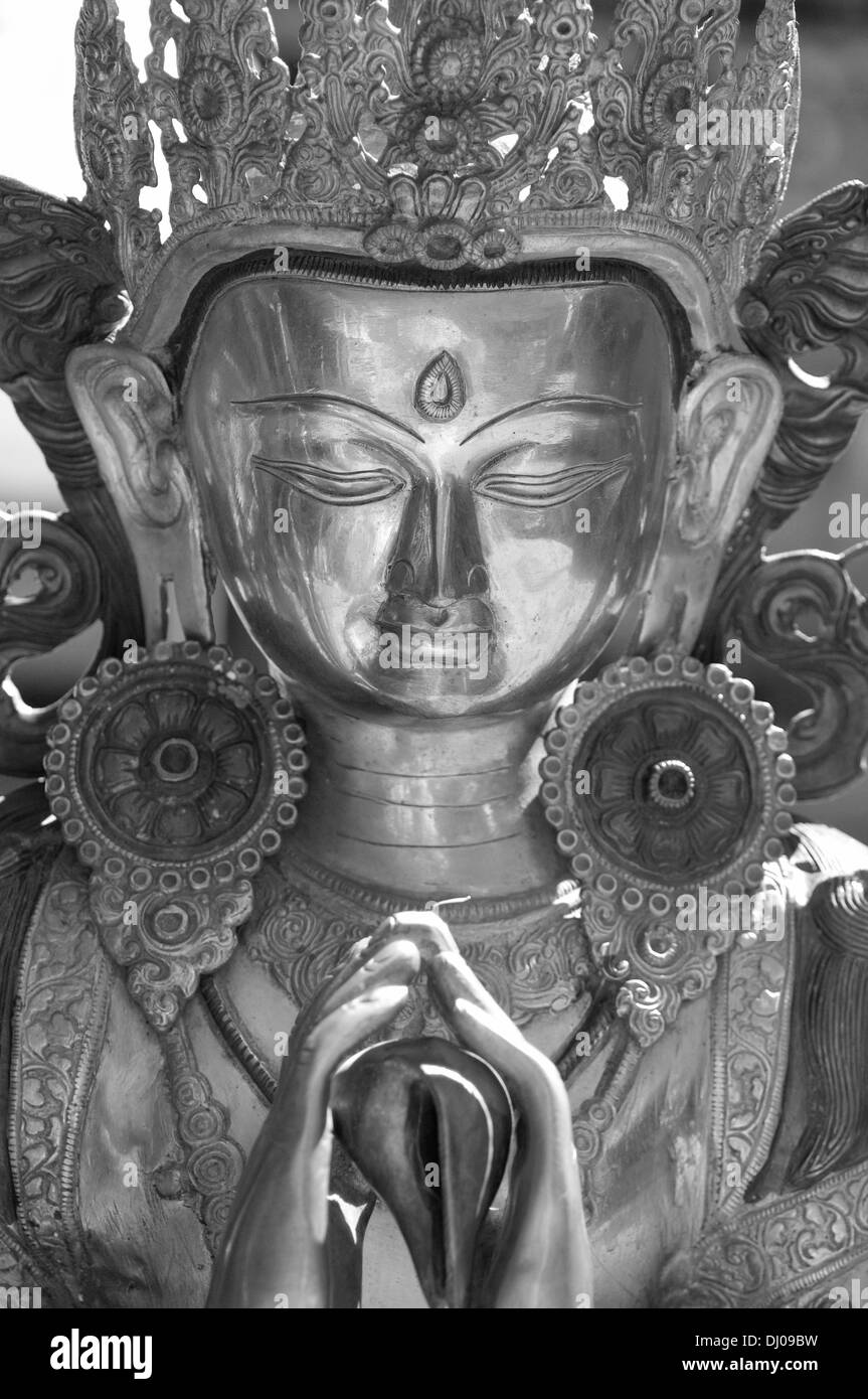 Buddista statua in bronzo di Manjushri corona di supporto e armi magici e talismani nel suo a 4 mani con serena faccia in seppia Foto Stock