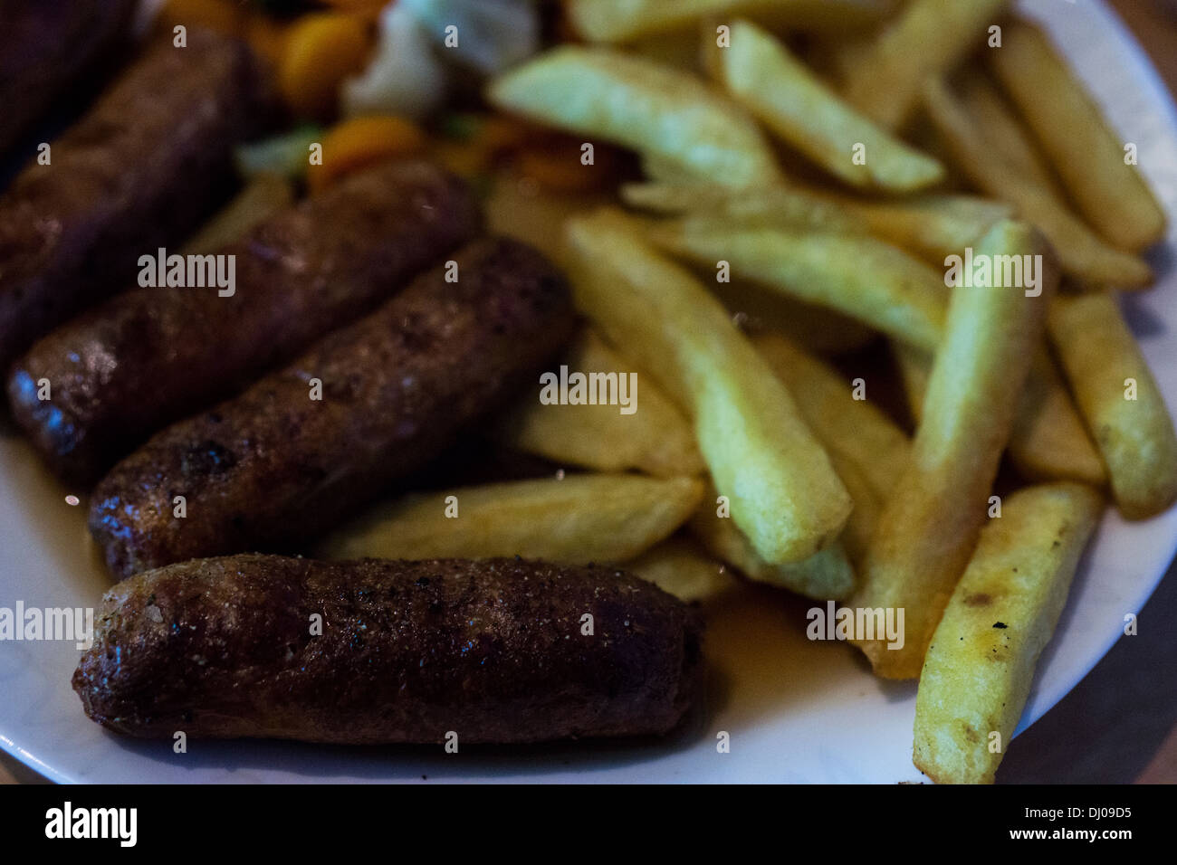 Patatine fritte con sugo di carne di salsiccia piatto di verdure Foto Stock