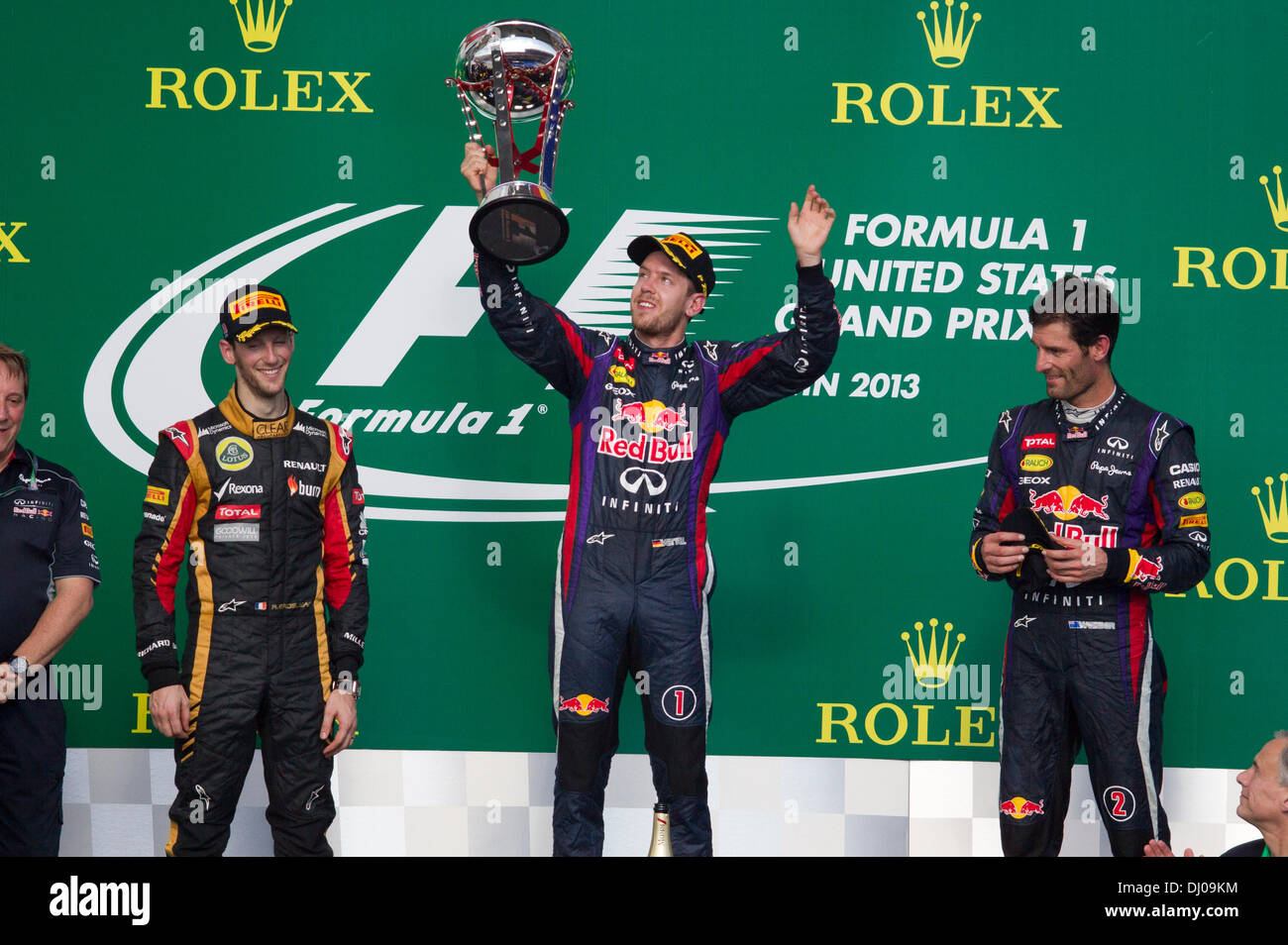Austin, Texas, Stati Uniti d'America. 17 novembre 2013. 17NOV13 Austin, TX Stati Uniti: vincitore Sebastian Vettel della Germania di paranchi la F1 Trophy come Romain Grosjean (l) e Mark Webber (r) guarda durante il periodo della Formula 1 Gran Premio degli Stati Uniti presso il circuito delle Americhe via nei pressi di Austin, TX. © Bob Daemmrich/Alamy Live News Foto Stock