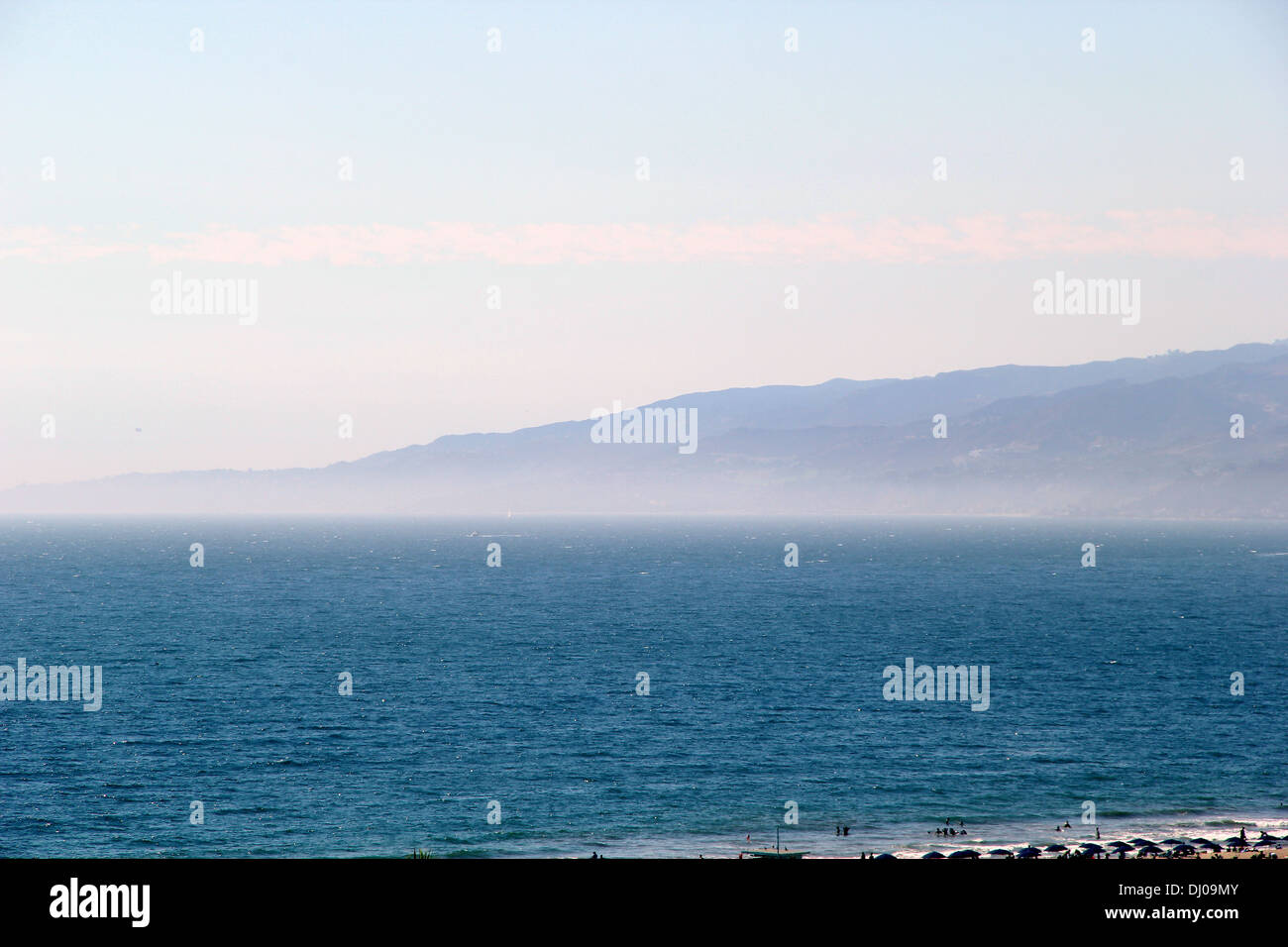 La vista dalla terrazza di un oceano blu e una montagna di distanza. Foto Stock