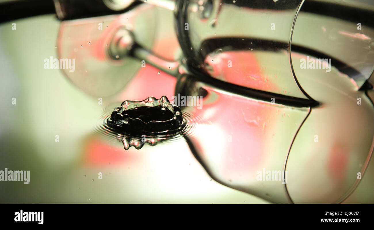 Ingrandimento di foto colorate di gocce di acqua bella forma corona su sfondo di vetro. Foto Stock