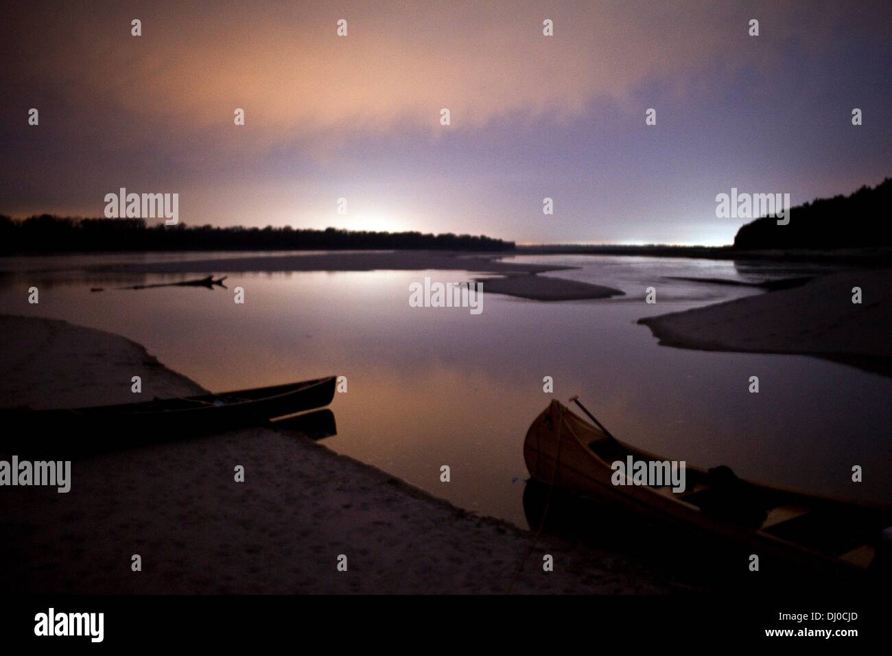 Memphis, Tennessee, Stati Uniti d'America. 4 Novembre, 2013. 11/04/13 - due canoe utilizzati durante il viaggio, un piede 16 in fibra di carbonio, canoa e 30 piedi di canoe di legno costruiti da John Ruskey, sono impastoiati in prossimità dell'acqua mentre le luci dalla città nelle vicinanze glow in lontananza durante la prima notte di cinque giorni di viaggio downriver. Il viaggio è stato il primo fiume Gator inaugurale di canoa che ha iniziato a Tamm's Landing in Lauderdale County, Tennessee e finito intorno 81 miglia dopo al Mudd isola. © Brad Vest/l'appello commerciale/ZUMAPRESS.com/Alamy Live News Foto Stock