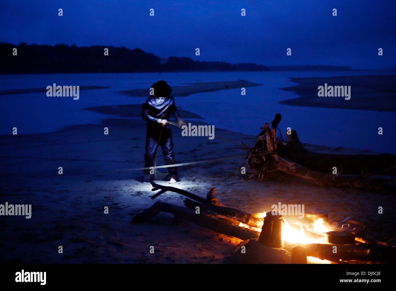 Memphis, Tennessee, Stati Uniti d'America. 7 Nov, 2013. 11/07/13 - Giovanni Ruskey, fondatore della canoa Quapaw Company, fissa una corda tenendo la sua mano costruito 30 piedi canoe di legno per un grande pezzo di driftwood durante una notte di vento sul fiume Mississippi. Il viaggio è stato il fiume Gator inaugurale di canoa che ha iniziato a Tamm's Landing in Lauderdale County, Tennessee e finito intorno 81 miglia dopo al Mudd isola. © Brad Vest/l'appello commerciale/ZUMAPRESS.com/Alamy Live News Foto Stock