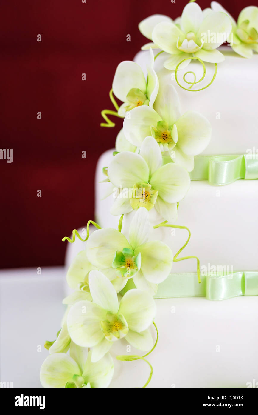 Torta di Nozze dettaglio con verde fiori di orchidea Foto Stock