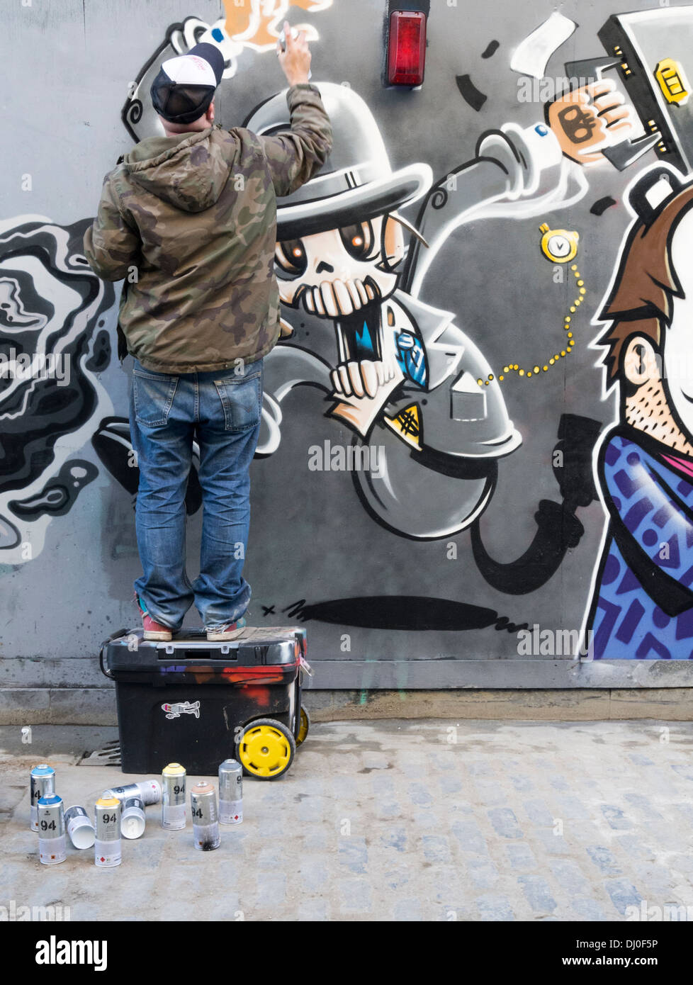 Graffiti artista al lavoro in Brick Lane, East London Foto Stock