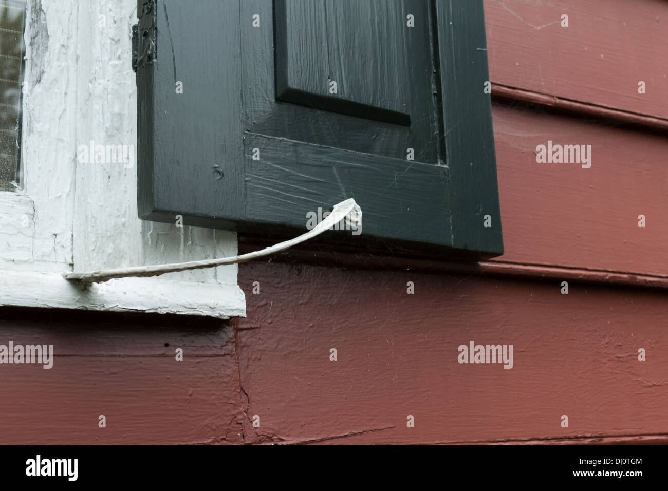Vecchia casa nero otturatori set contro il rivestimento bianco e rosso infissi in legno rivestimenti Foto Stock