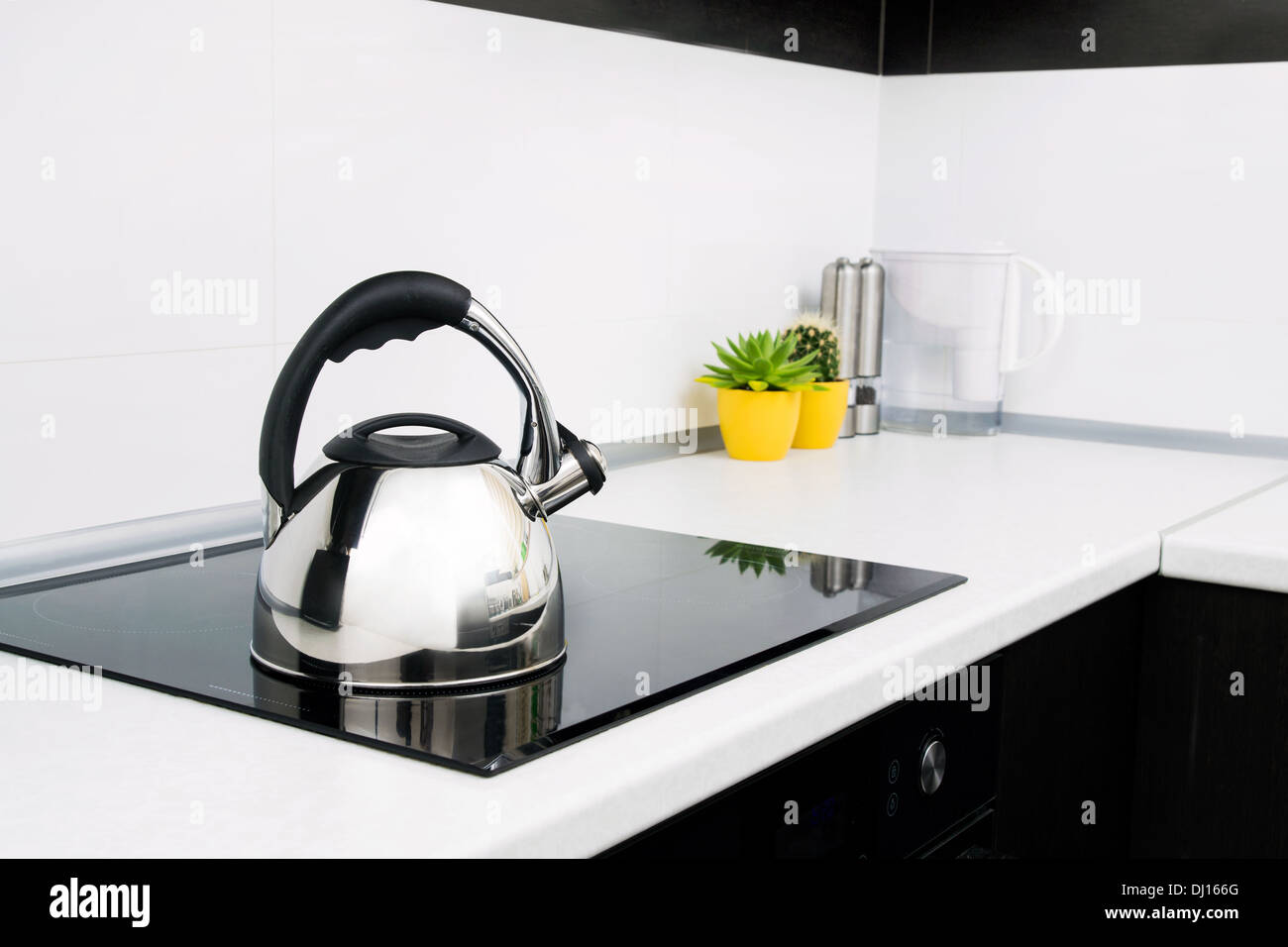 Bollitore in acciaio nella moderna cucina con fornelli a induzione Foto Stock