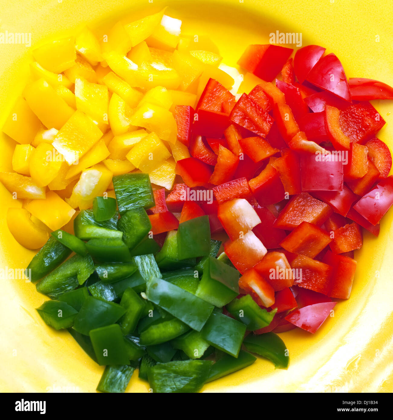 Il giallo, il verde e il rosso a fette il peperone su piastra Foto Stock