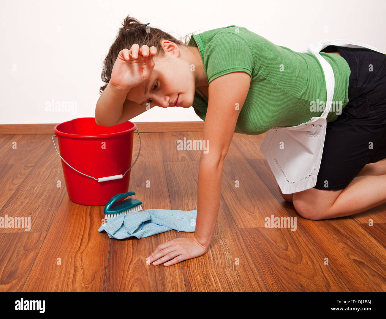 La donna a essere stanchi dopo una giornata di duro lavoro di pulizia del pavimento Foto Stock