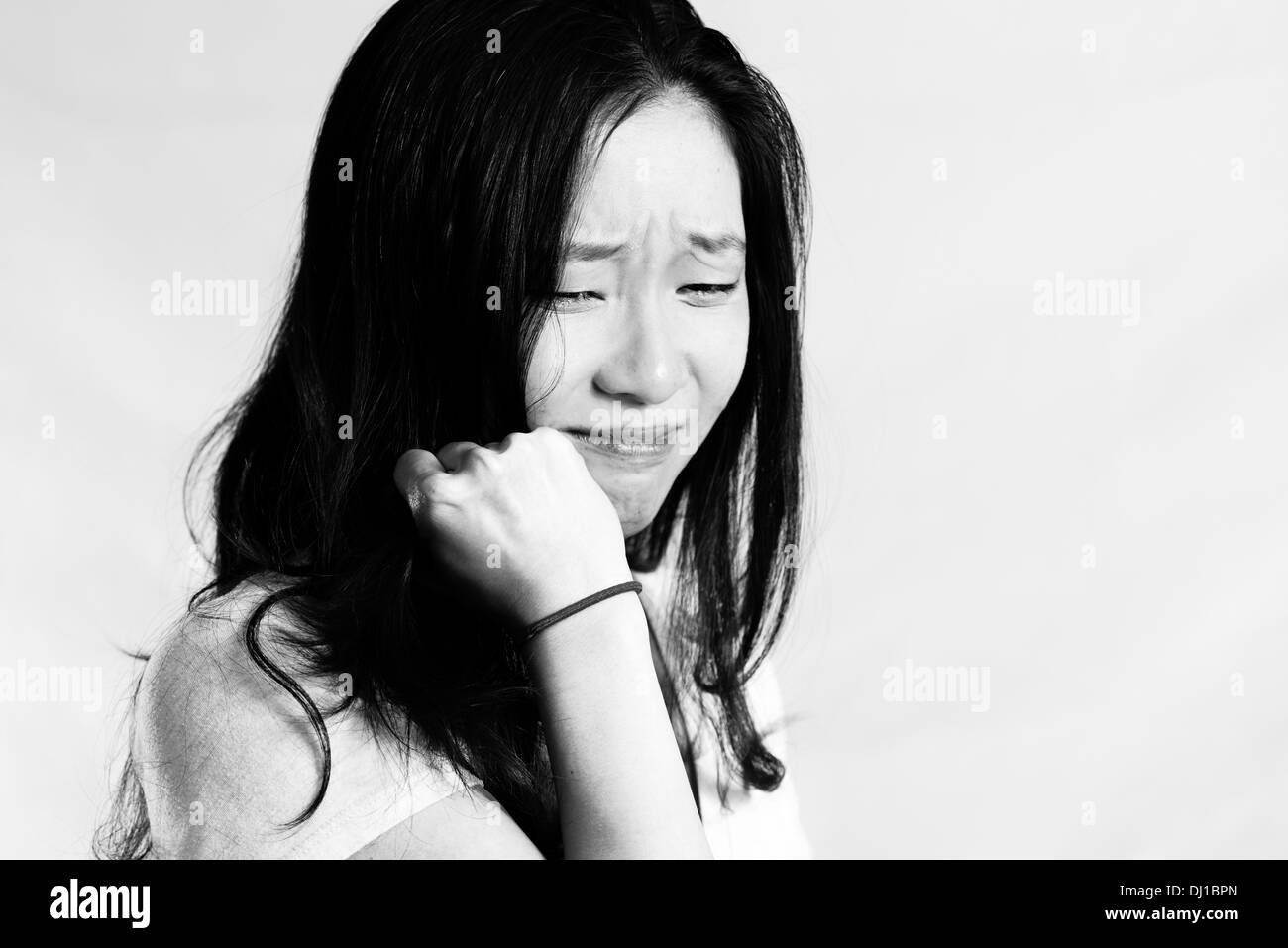 Ritratto di giovane donna che piange mentre si tira i capelli, in bianco e nero style Foto Stock