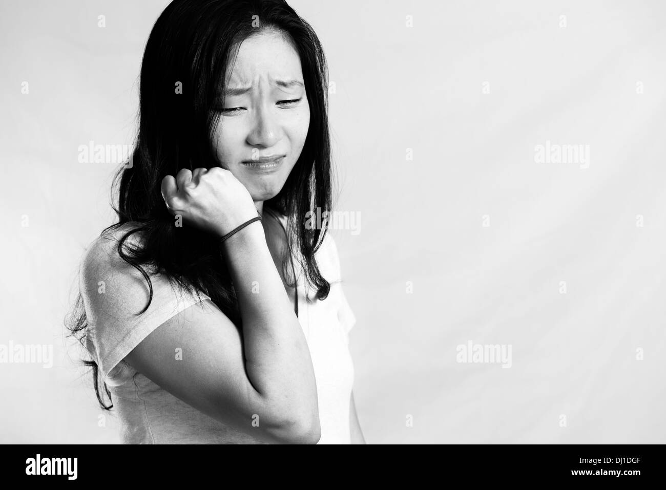Ritratto di giovane donna che piange mentre si tira i capelli, in bianco e nero style Foto Stock