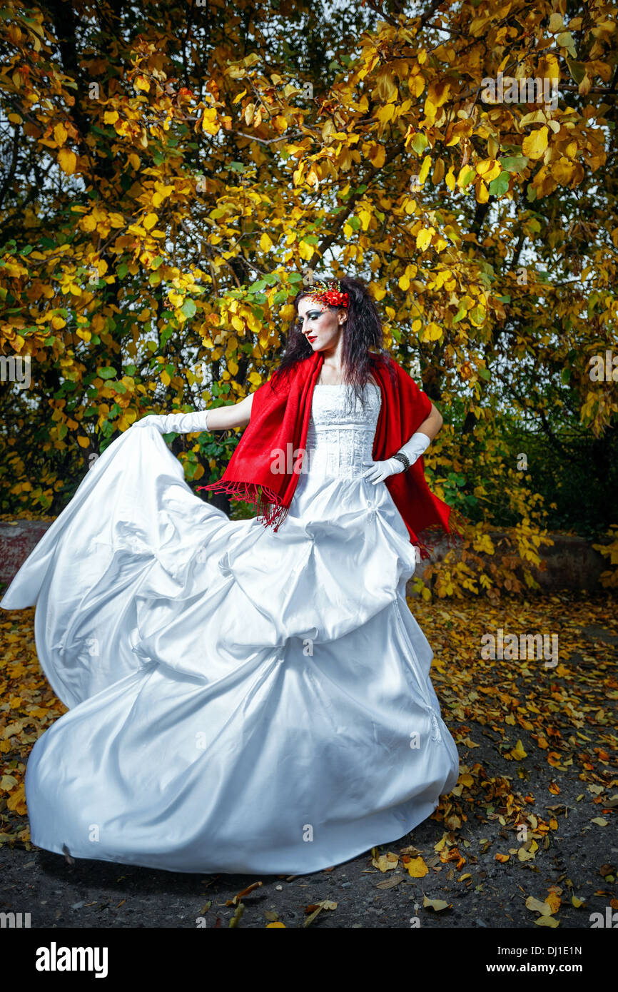 Sposa attraente in un abito da sposa con brillante trucco, scialle rosso Foto Stock