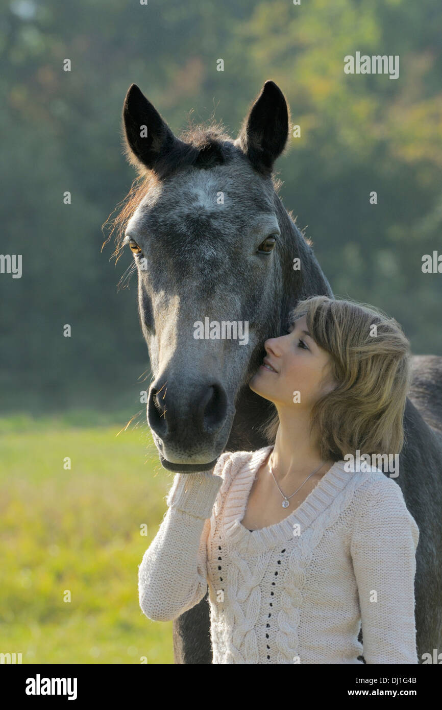 Giovane donna cuddling suo pony Connemara Foto Stock