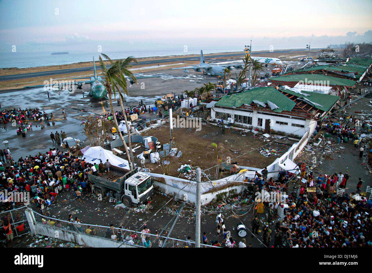 I residenti si riuniranno presso il distrutto Tacloban Airfield per evacuazione a Manila all indomani della Super Typhoon Haiyan Novembre 14, 2013 in Tacloban, Filippine. Foto Stock