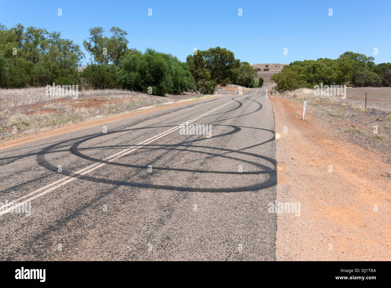 Burn Out auto tracce di pneumatici sulla strada da spiinning ruote vettura, Murchison Australia Occidentale Foto Stock