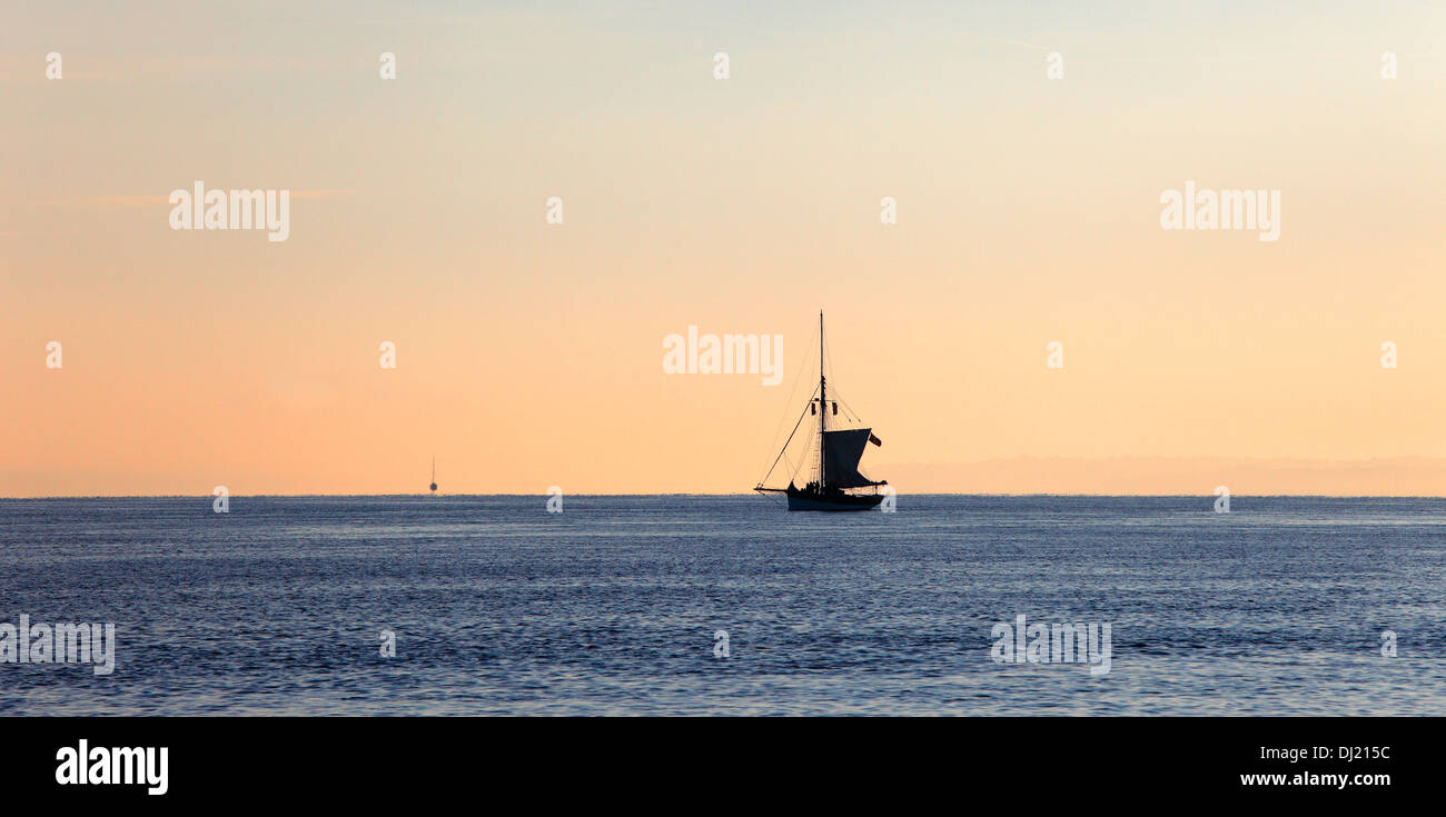 Sloop vela on Solent in early morning light Solent Isle of Wight Hampshire Inghilterra Foto Stock
