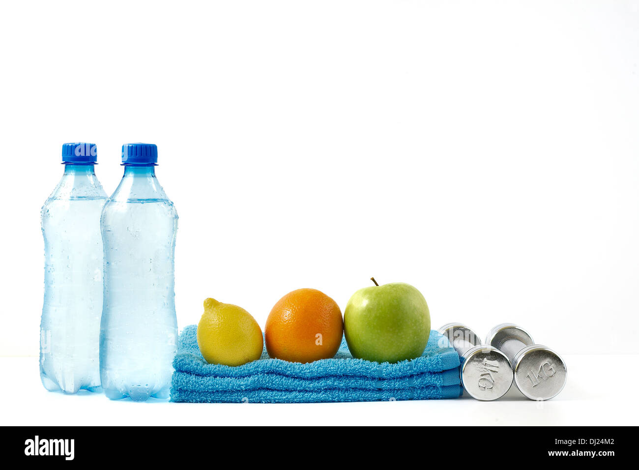 Frutti con manubri fitness e acqua su sfondo bianco. Foto Stock